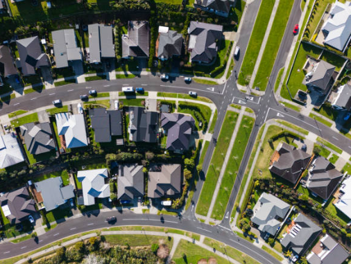 紐西蘭一個整齊郊區的鳥瞰圖,畫面中有多棟獨立房產與街道,象徵著紐西蘭的房地產市場與買房選擇的多樣性
